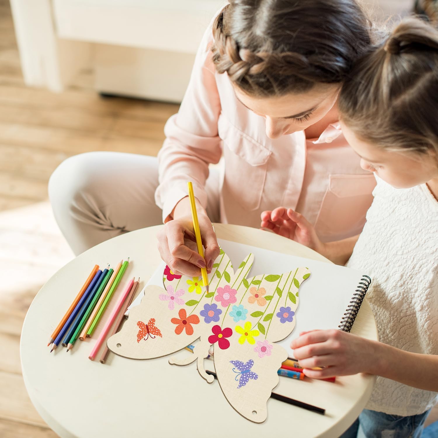 Two children drawing with colorful pencils on a table.