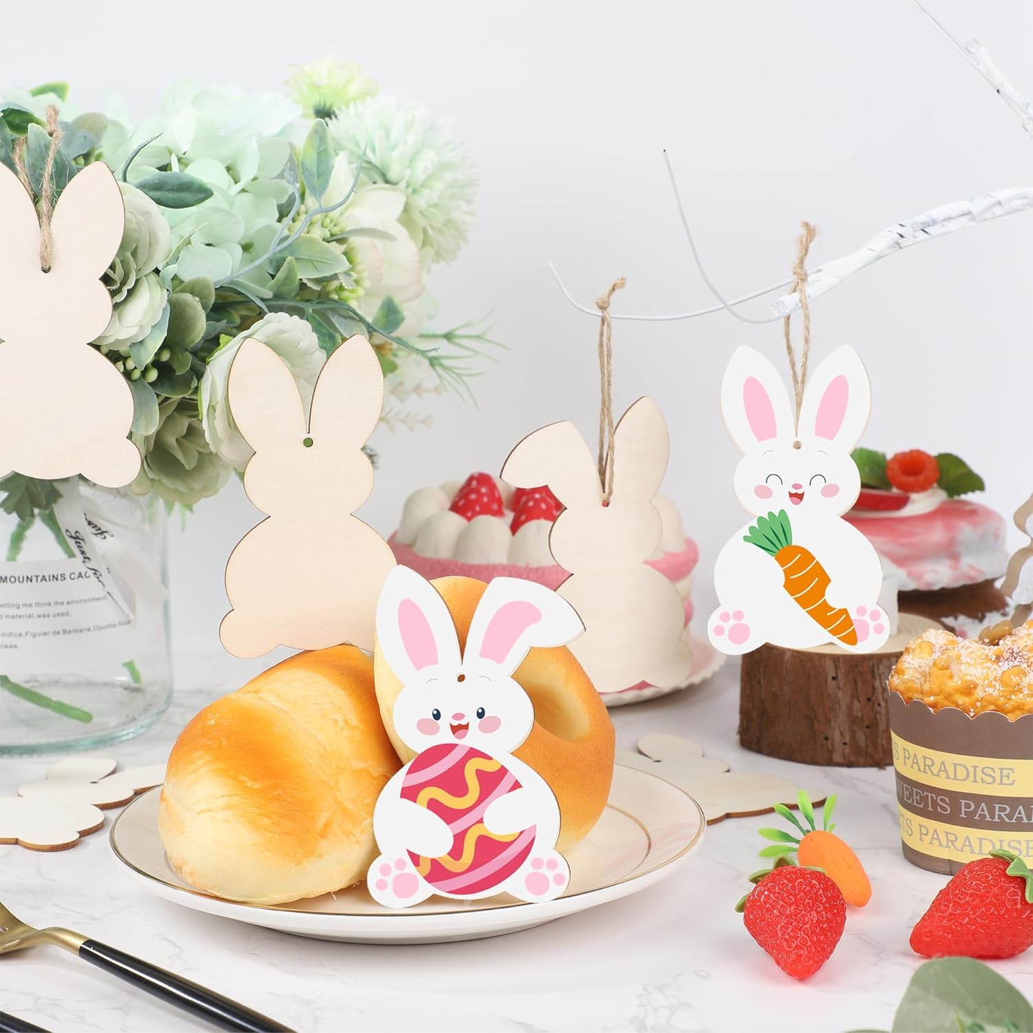 Decorative bunny cards with pastries and fruits on a table