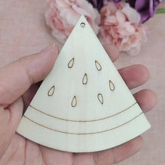 Wooden triangle-shaped ornament with cut-out details held in a hand against a floral background