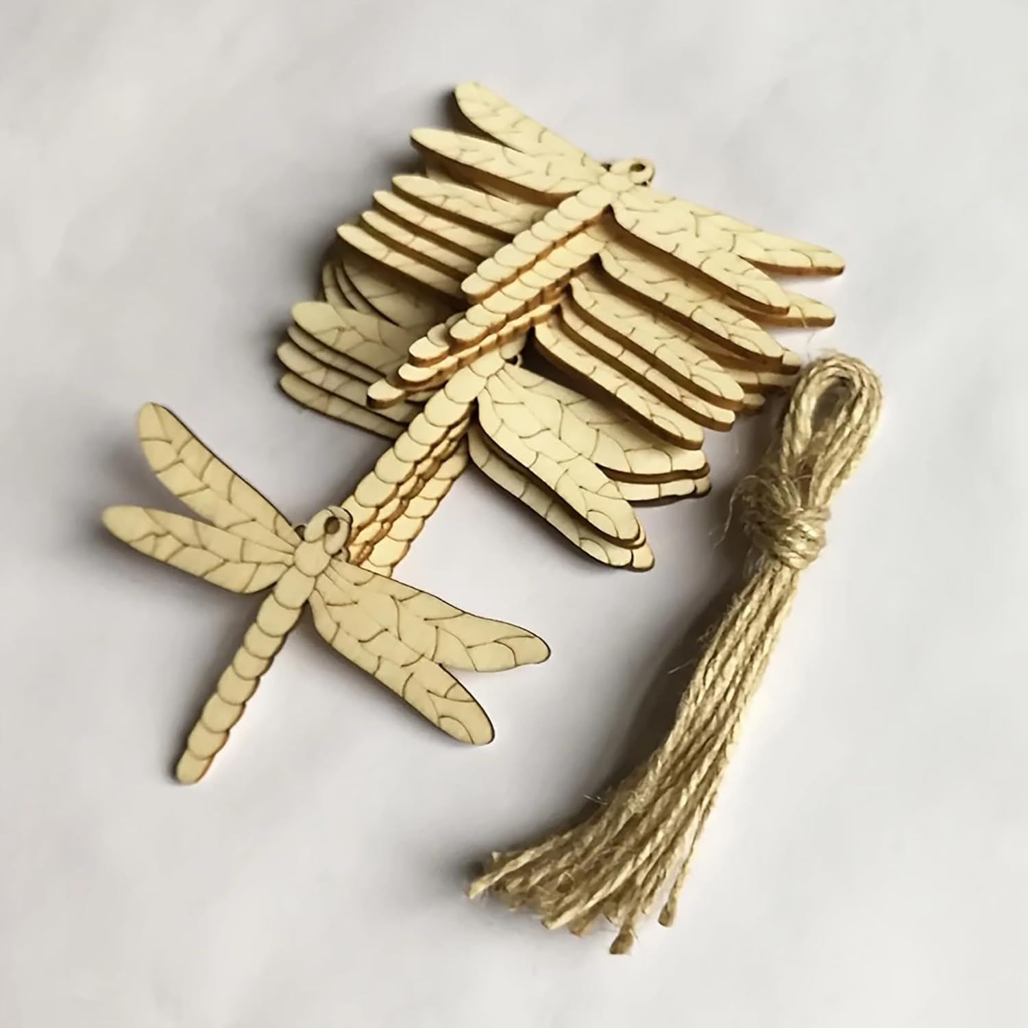 Gold dragonfly ornament with tassel on a light gray background