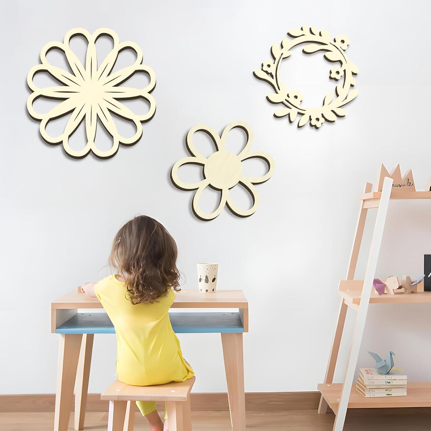 Child sitting at a desk with decorative wall mirrors on a light gray wall.