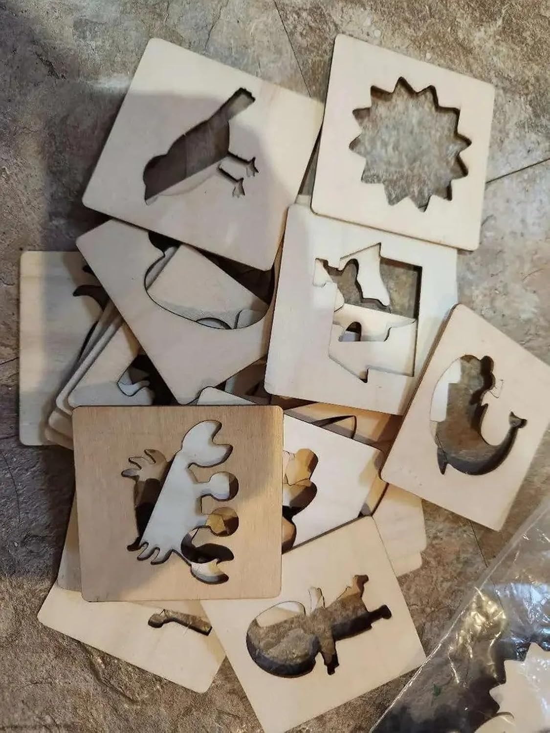 Set of wooden stencils with various shapes on a stone surface