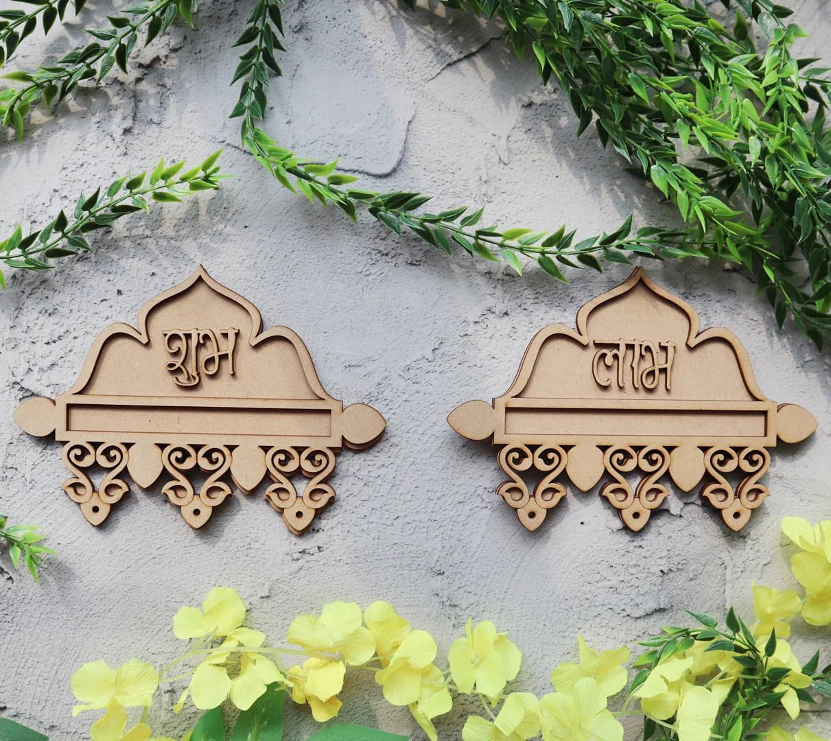 Two wooden decorative items with engraved names on a stone surface with greenery and flowers.