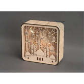 Wooden decorative box with cut-out designs and LED lights on a gray background