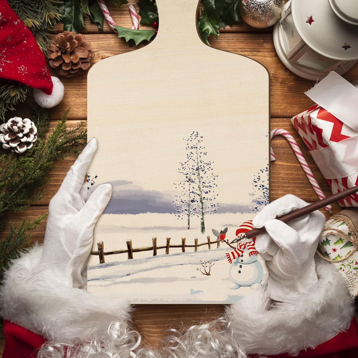 Person wearing white gloves holding a snowy landscape painting with Christmas decorations around.