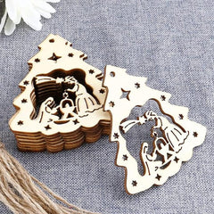 Wooden nativity scene cutouts on a textured surface with white flowers.