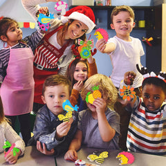Group of children and a teacher in a classroom setting with craft materials.