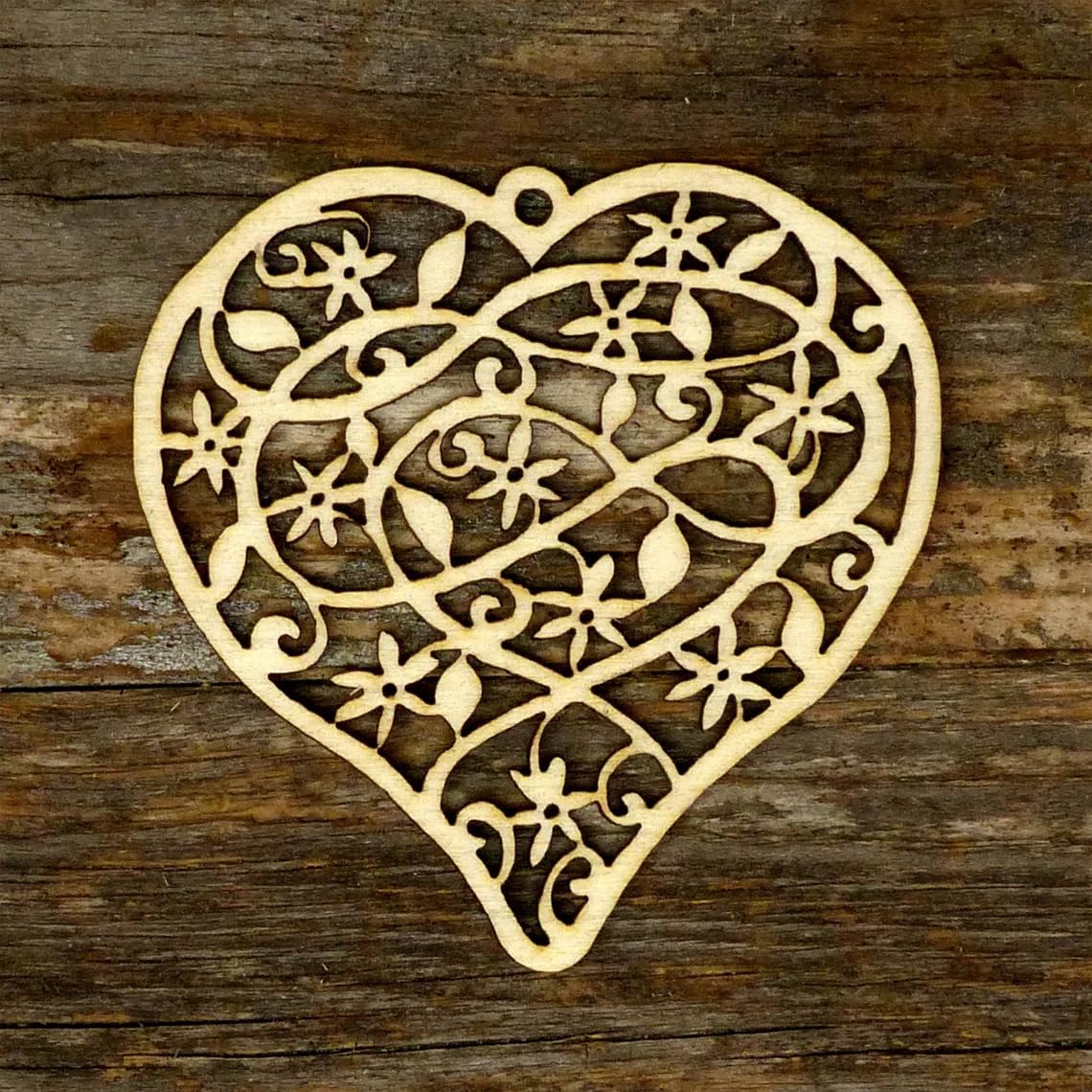 Decorative heart-shaped cutout with intricate patterns on a wooden surface