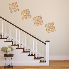 Decorative wall art above a staircase with a side table and flowers.
