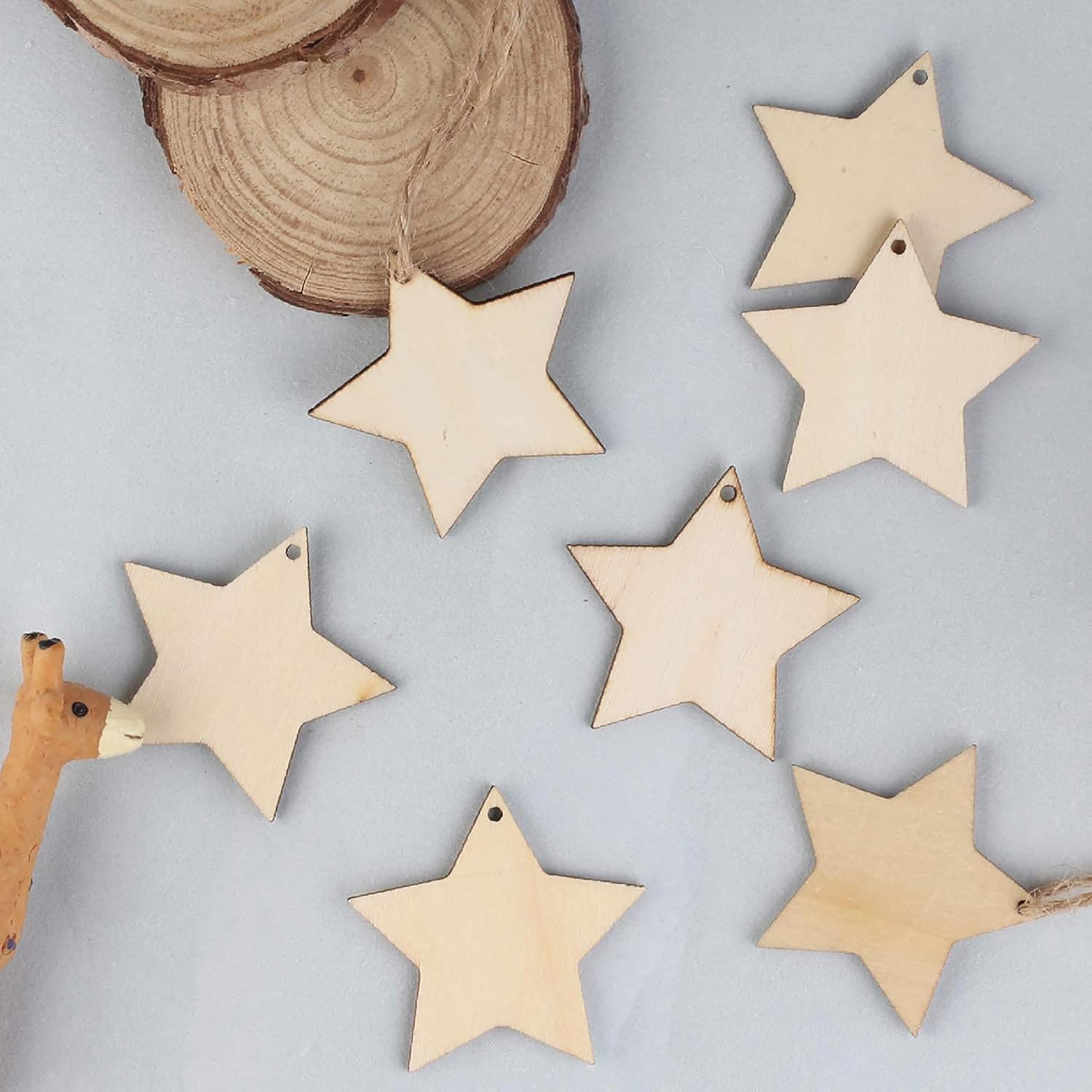 Wooden star-shaped ornaments on a light gray background with a wooden log.