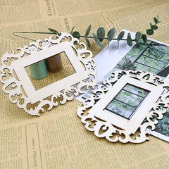Two white decorative picture frames on a textured surface with greenery.