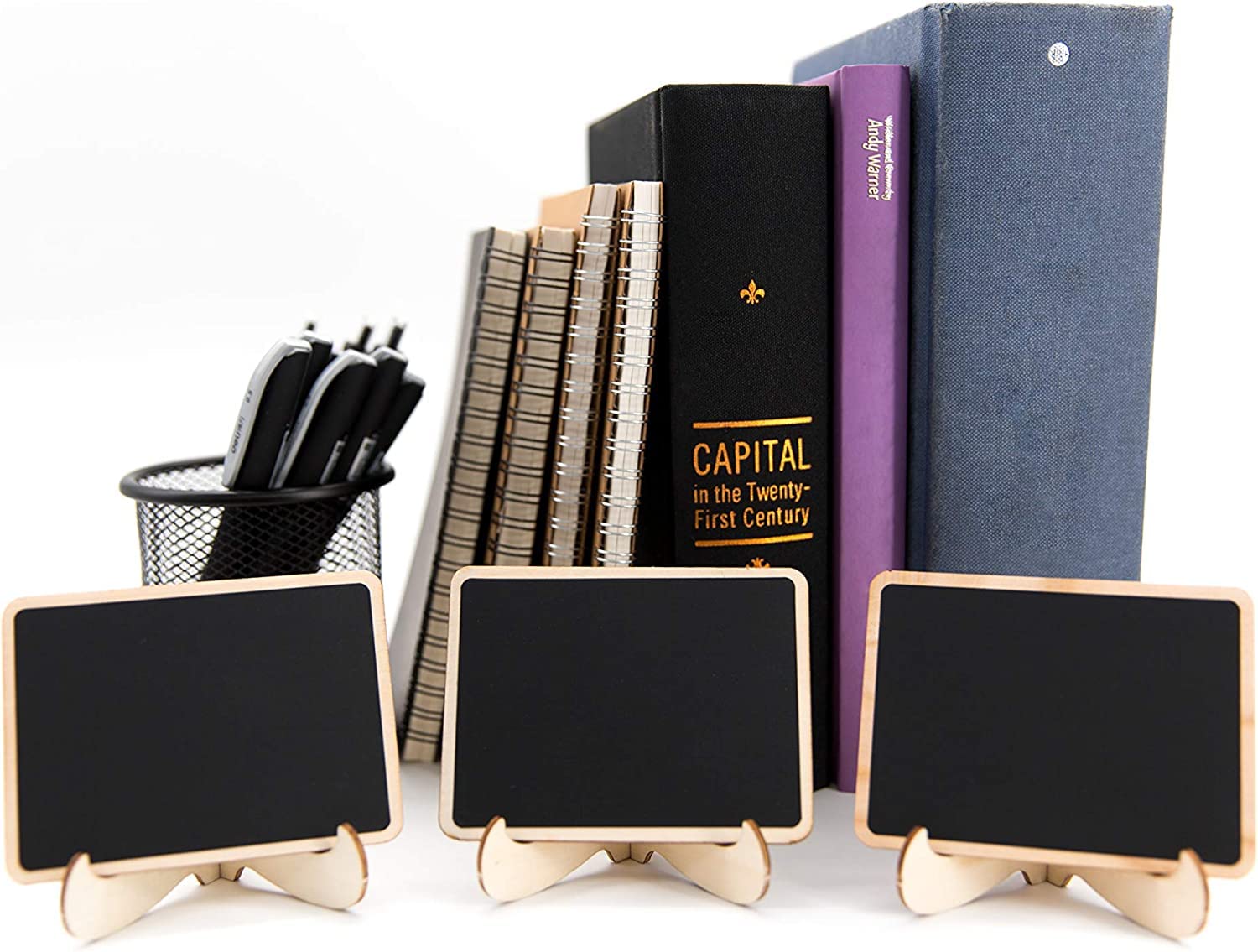 Three small blackboards on stands with books and a pen holder in the background.