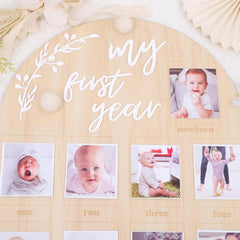 Wooden photo display with 'my first year' text and baby photos.