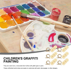 Art supplies including a watercolor set, paintbrushes, and children's graffiti painting materials on a wooden surface.