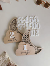 Wooden baby milestone markers with numbers and months on a light background