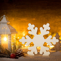 Decorative snowflake with a lantern and Christmas tree in the background