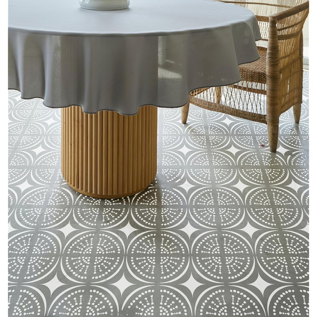 Round table with a gray tablecloth on a patterned floor