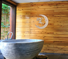 Marble bathtub in a bathroom with wooden wall and decorative fairy on moon design