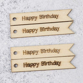 Four wooden tags with 'Happy Birthday' text on a gray surface