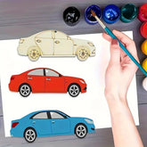 Coloring book with cars and a hand holding a paintbrush over a set of colored paints.