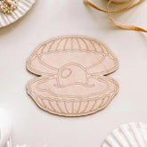 Wooden shell-shaped ornament with a small pearl inside on a light background
