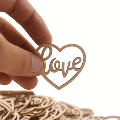 Heart-shaped wooden ornament with 'love' engraving held by a hand against a white background