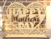 Wooden heart-shaped decorative sign with 'Happy Mother's Day' text on a blurred background