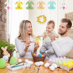 Family of three engaging in Easter activities with eggs and decorations.