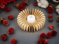 Decorative wooden candle holder with red pinecones and cotton on a dark surface
