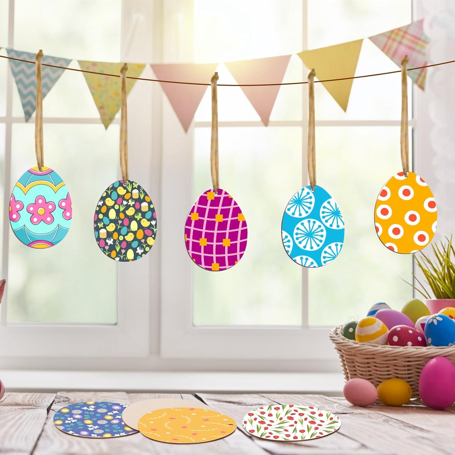 Colorful Easter egg decorations hanging on a line with a basket of eggs and bunting in the background.