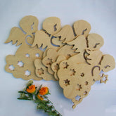 Wooden cutout shapes of angels and flowers on a white background