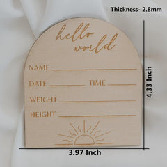 Wooden baby milestone board with 'hello world' text and measurement details on a white background