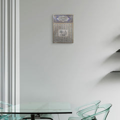 Decorative wall art with Arabic calligraphy on a white wall above a glass table.