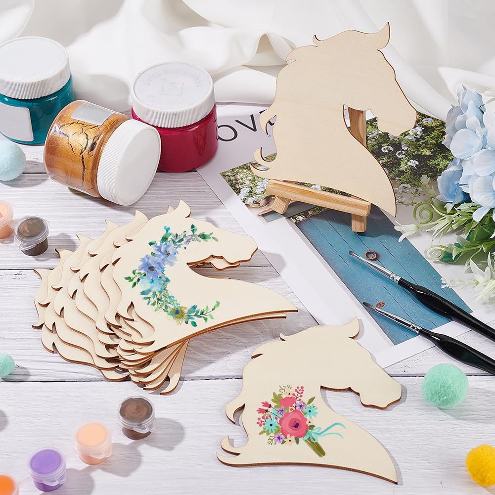 Wooden horse shapes with floral designs on a table with paint jars and brushes.