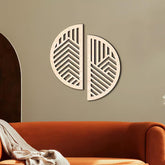 Decorative wall art with geometric patterns on a beige wall above an orange sofa.