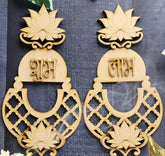 Pair of decorative earrings with lotus designs and text on a dark background