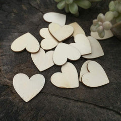 Wooden heart shapes on a dark surface with succulents in the background