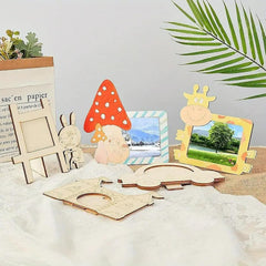 Collection of wooden photo frames and decorative items on a white surface with green leaves in the background.