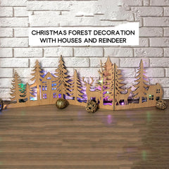 Wooden Christmas forest decoration with houses and reindeer on a wooden surface and brick wall background.