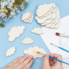 Crafting activity with cloud-shaped wooden pieces on a blue surface.
