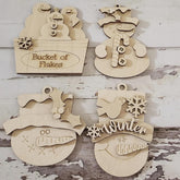 Wooden Christmas ornaments shaped like a bucket of snowflakes, snowman, and other winter-themed items on a rustic wooden background.
