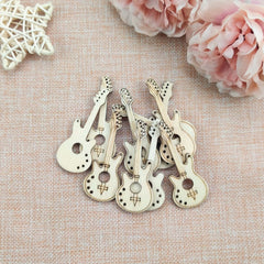 Wooden guitar-shaped bottle openers on a textured surface with pink flowers.
