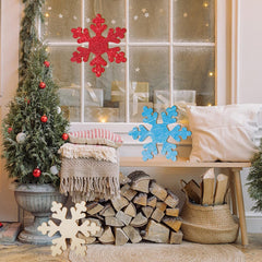 Cozy living room with Christmas decorations, including a tree, snowflakes, and stacked firewood.