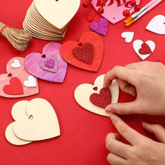 Heart-shaped paper crafts on a red background with hands arranging them.