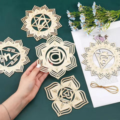Decorative paper cutouts with intricate designs on a green surface with flowers and a letter.