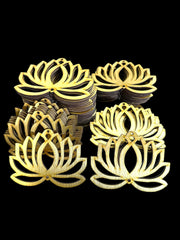 Gold lotus-shaped coasters stacked on a black background