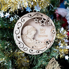 Wooden ornament with baby design and 'Baby's First Christmas' text on a decorated tree.