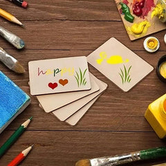 Children's art project with painted cards and craft supplies on a wooden table