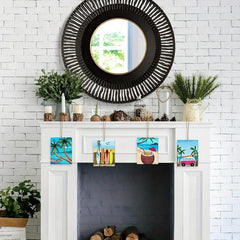 Decorative mantel with a black round mirror, plants, and small colorful artworks against a white brick wall.