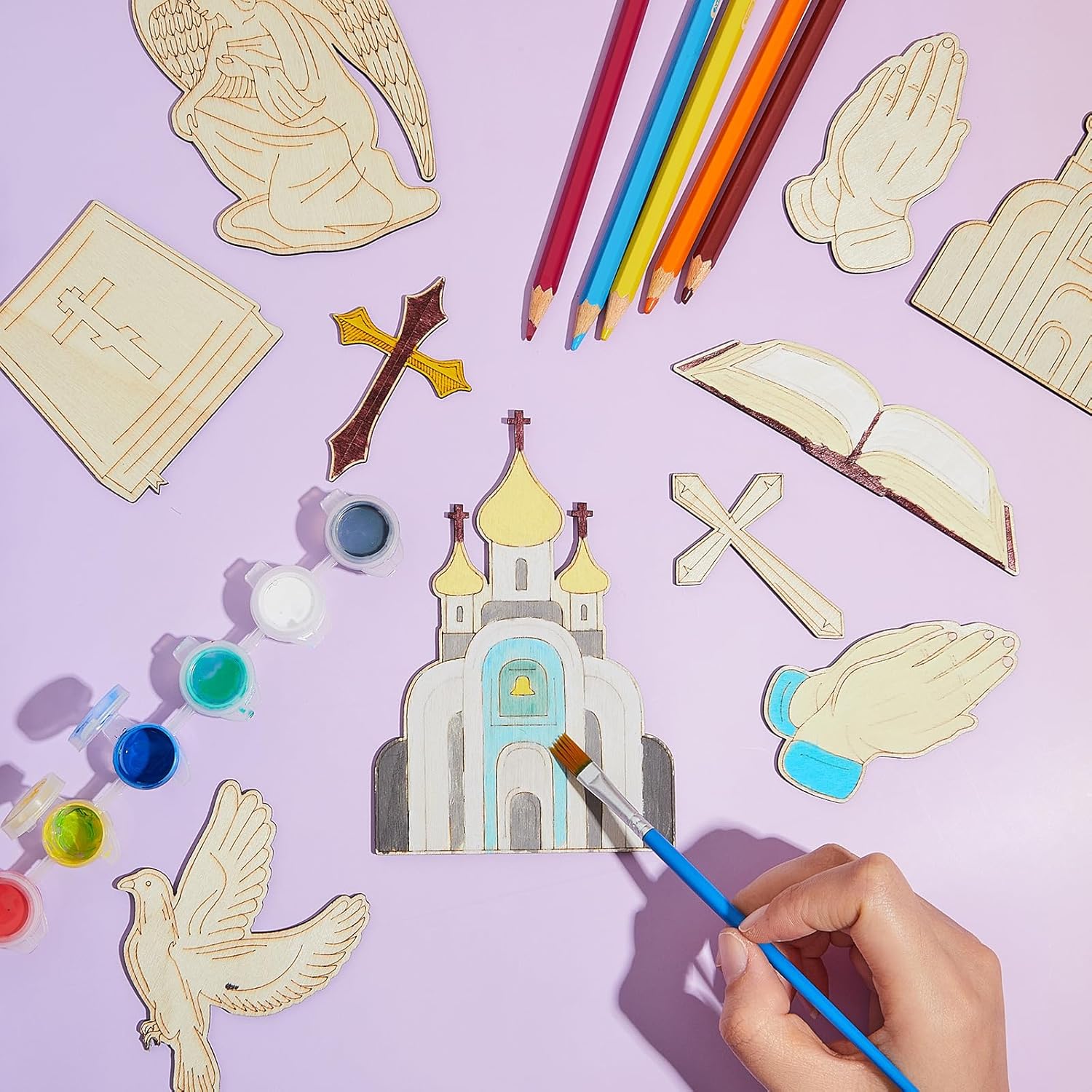 Coloring craft set with religious-themed items on a purple background